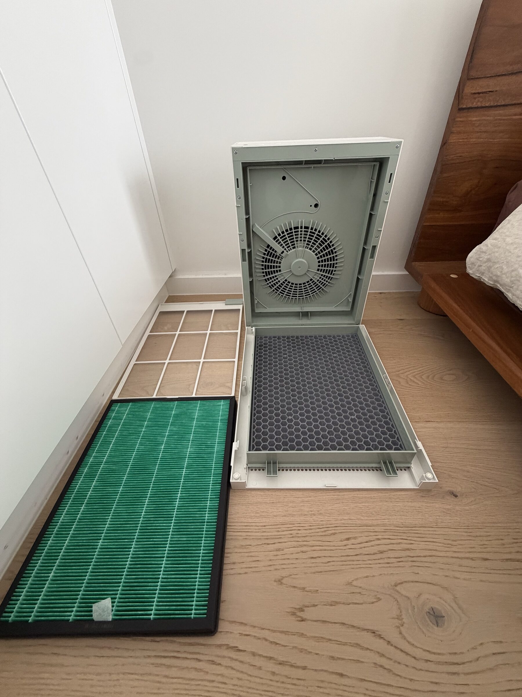 Coway Airmega 150 with cover removed showing all three filter layers: pre-filter, carbon honeycomb panel, and GreenHEPA pleated filter