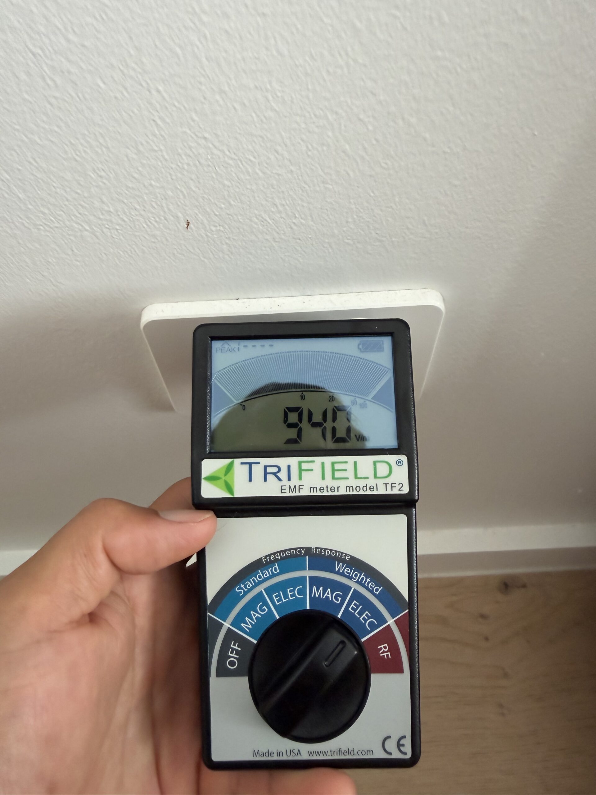 TriField TF2 measuring 0.124 mW/m² RF microwave field at hallway plantation shutters with bedroom router on timer — Jayce Love first-hand testing, Clean and Native