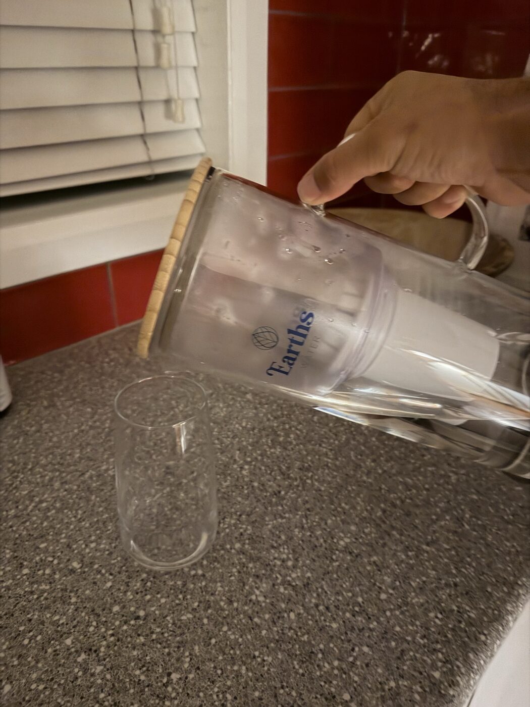 Earth's Water 3.5L glass carafe being poured — real owner photo