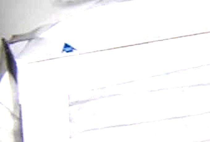 Close-up of the blue airflow direction arrow printed on a MERV-13 filter cardboard frame, used for correctly orienting Corsi-Rosenthal box filters
